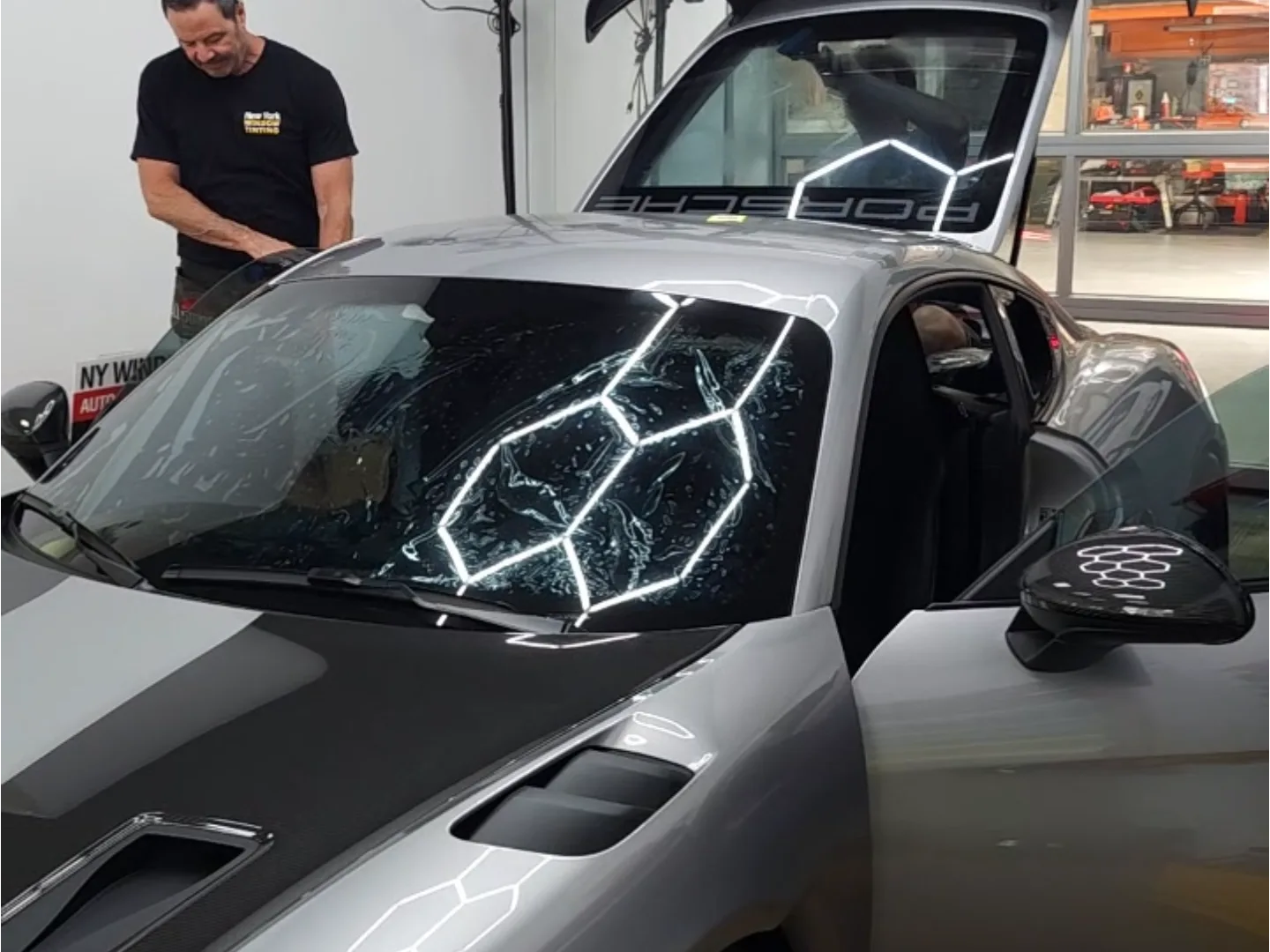 PPF window film installation in progress on a Porsche windshield at NY Window Tinting